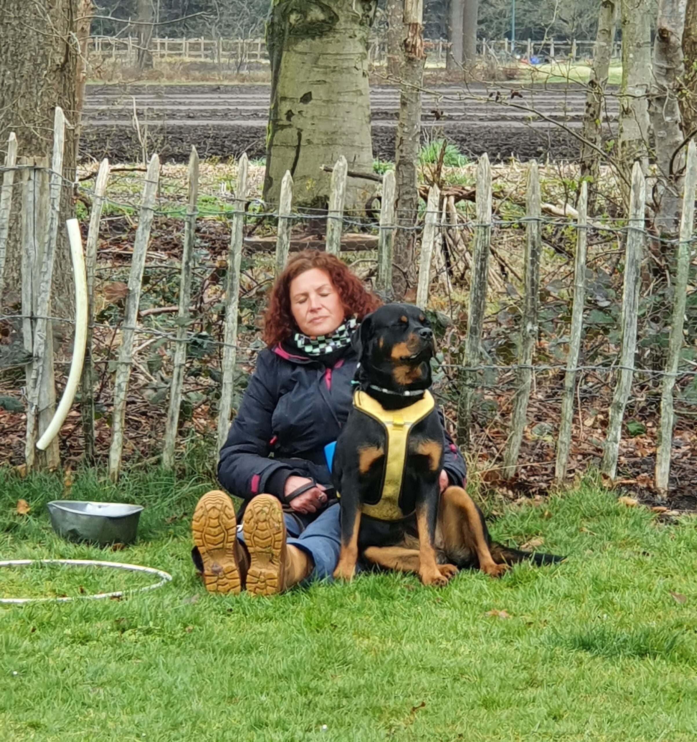 Cursist zit met eigen hond ruggelings op bankje bij Ontdek de Spiegel van je eigen hond bij Hondenspiegel